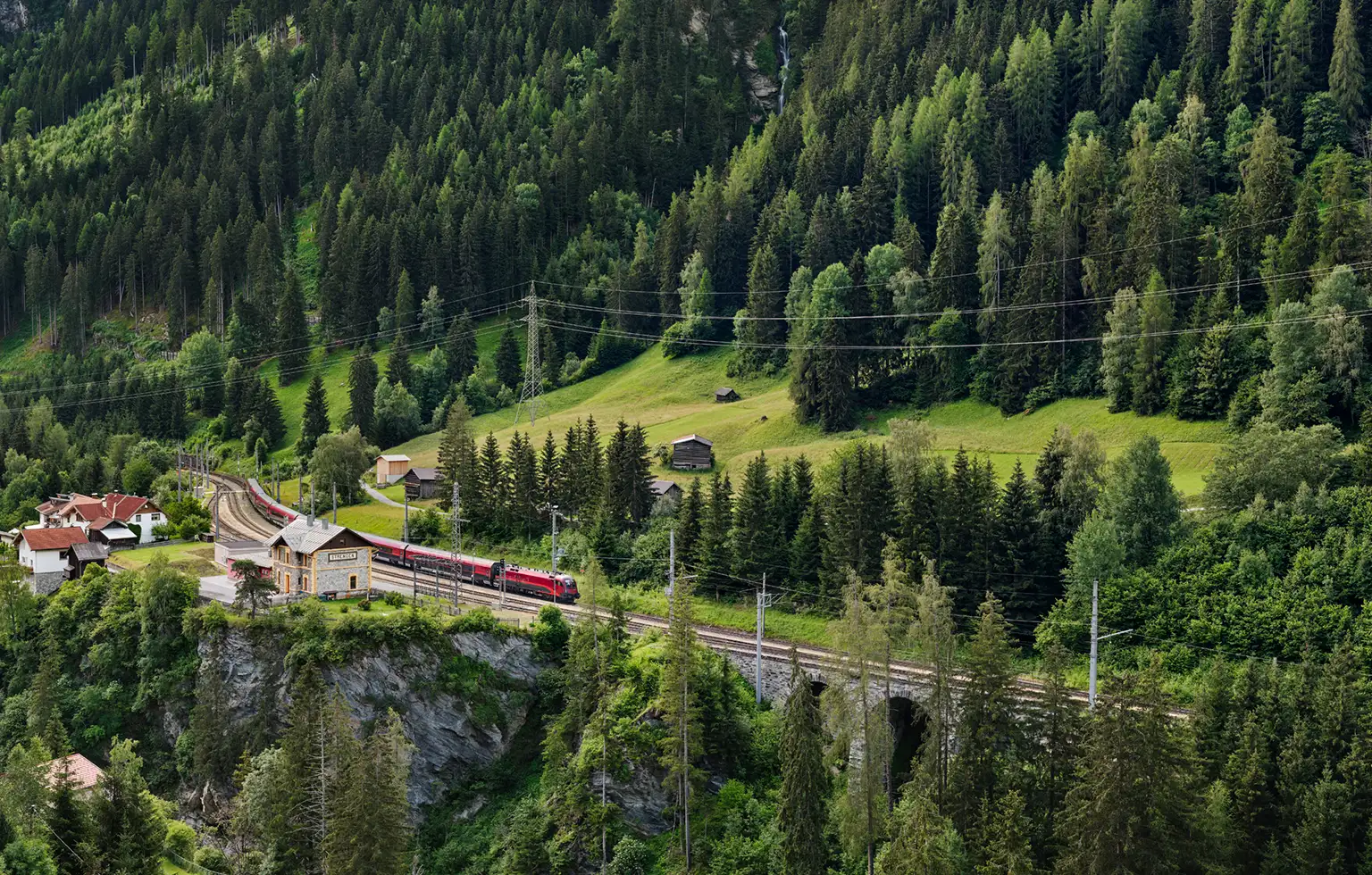 Zug der Arlbergbahn am Bahnhof in Strengen in Tirol in Österreich